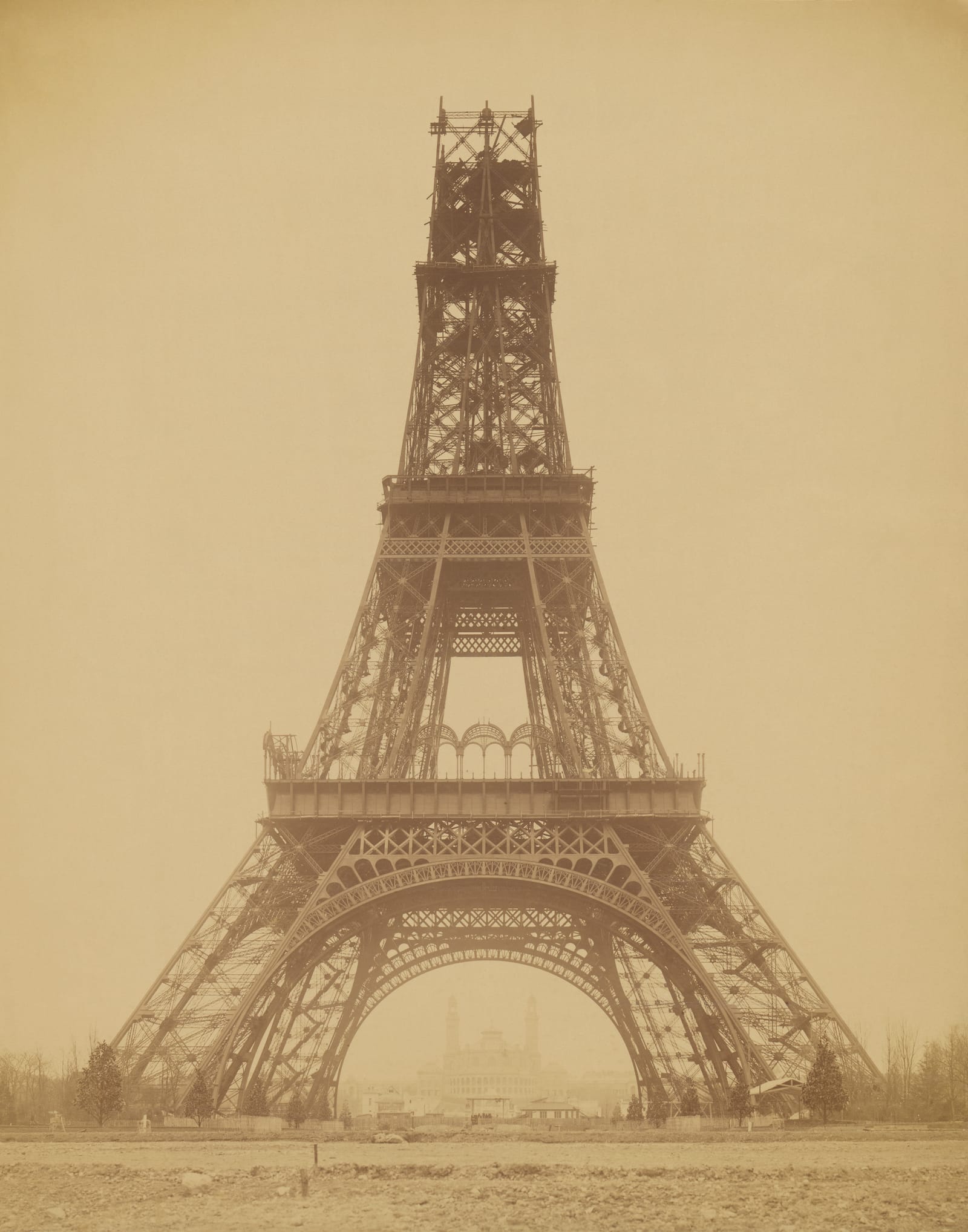 The Eiffel Tower half built, with its first and second floors finished and scaffolding round the top