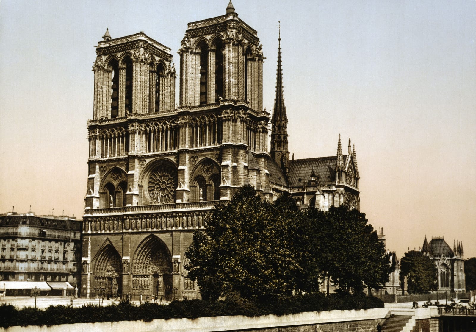 Notre-Dame from the river, with its two towers and the slender spire rising over the roof behind them
